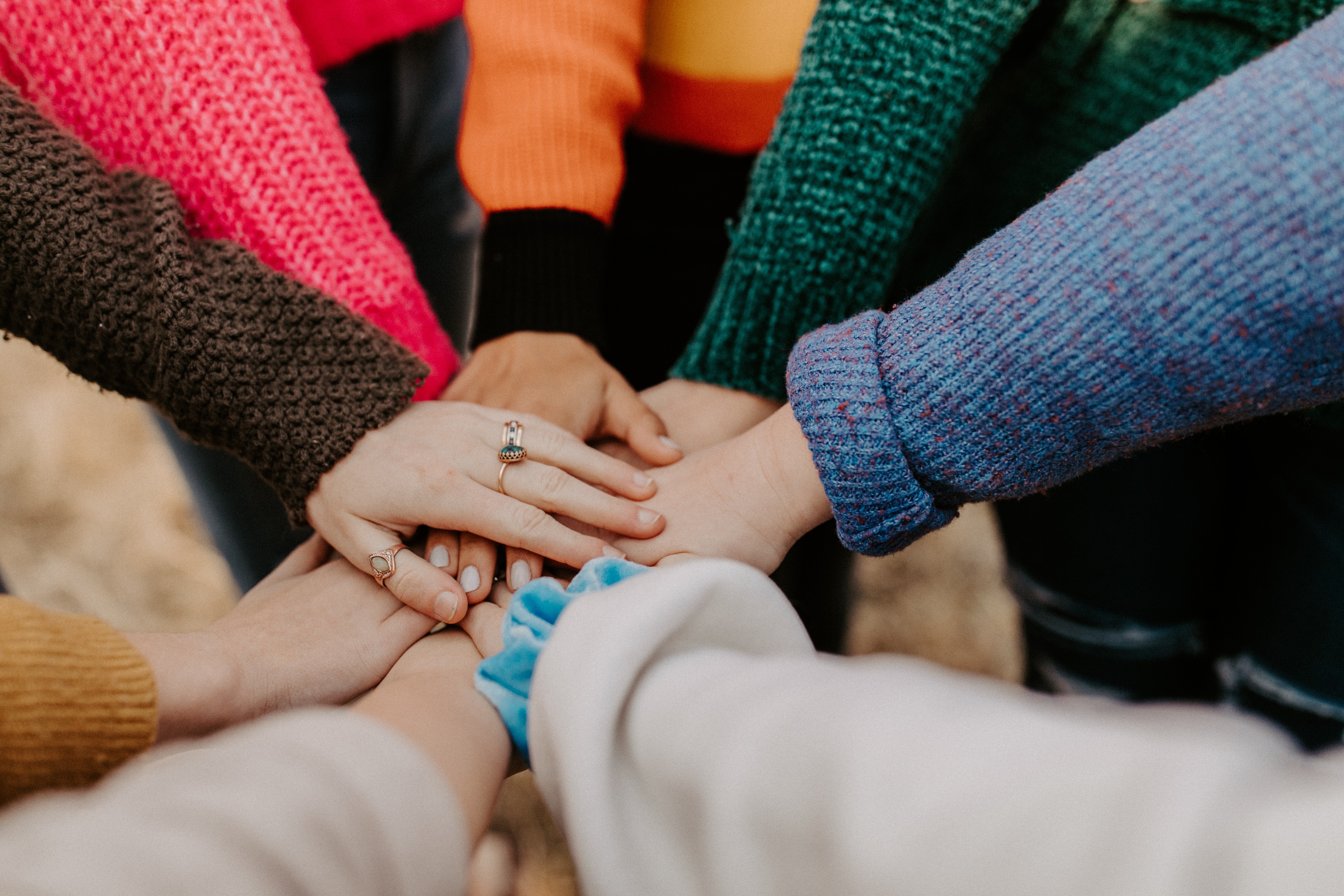 Hands in the middle with colorful sweater sleeves